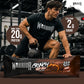 Warrior Crunch Soft Core Fudge Brownie protein bar wrapper on a gym floor, with a man in Warrior kit holding a kettlebell behind it and callouts for more than 20g protein and less than 2g sugar.