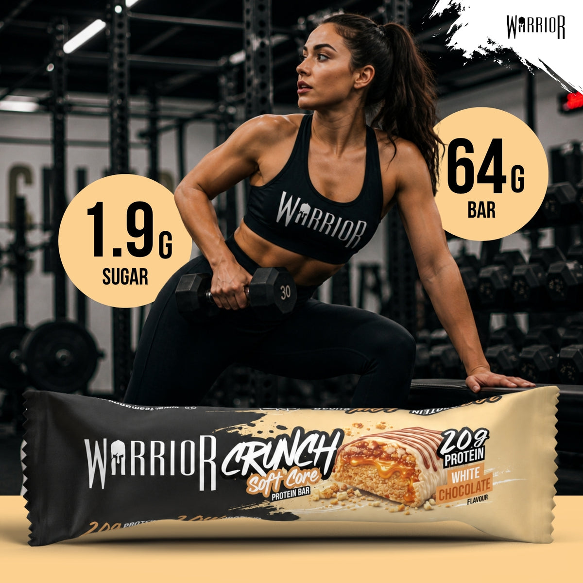 Warrior Crunch Soft Core White Chocolate protein bar wrapper on a gym floor, with a woman in Warrior kit holding a dumbbell behind it and callouts for 1.9g sugar and a 64g bar.