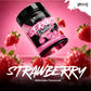 A tub of Warrior Serious Protein Strawberry Milkshake tilted amongst fresh strawberries on a pink background, with large 'STRAWBERRY' text and 'Milkshake Flavoured' at the bottom, and the Warrior brand logo in the top right.