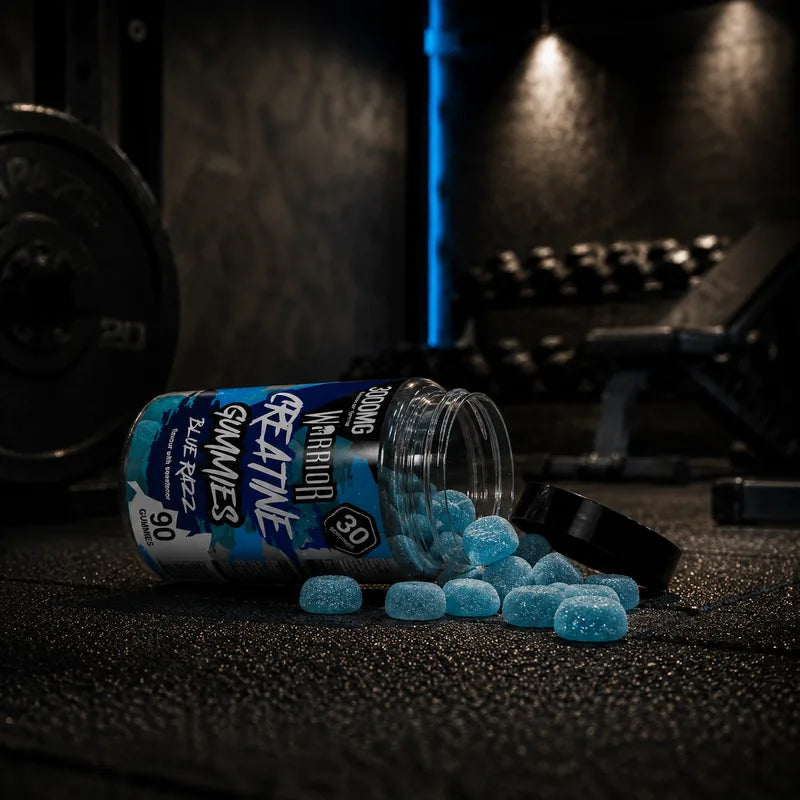 Warrior Creatine Gummies Blue Razz flavour jar, 3000mg creatine per serving, 90 gummies, 30 day supply tag and Lab Tested Verified badge, with blue raspberries and two gummies in foreground